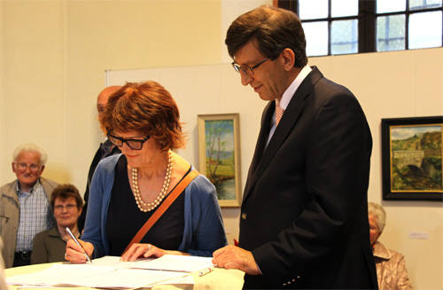 Christine Steyer und Bürgermeister Horn unterschreiben die Schenkungsurkunde.